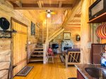 Enter the cabin into an open concept kitchen, dining area and living room with fireplace